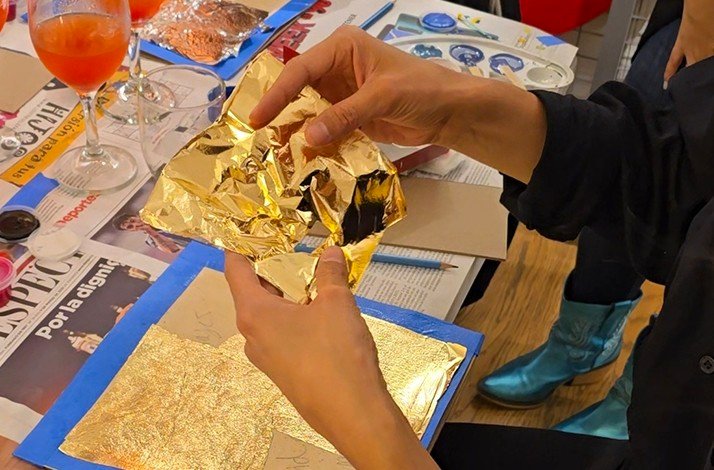 Hands delicately handling golden foil, crafting detailed artistic pieces
