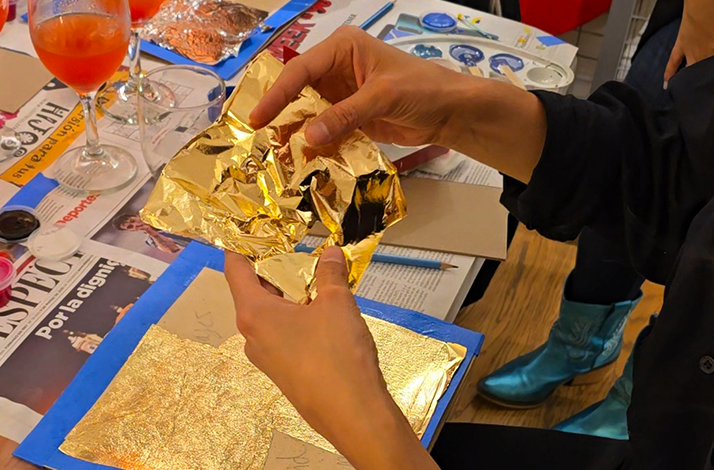 Hands delicately handling golden foil, crafting detailed artistic pieces