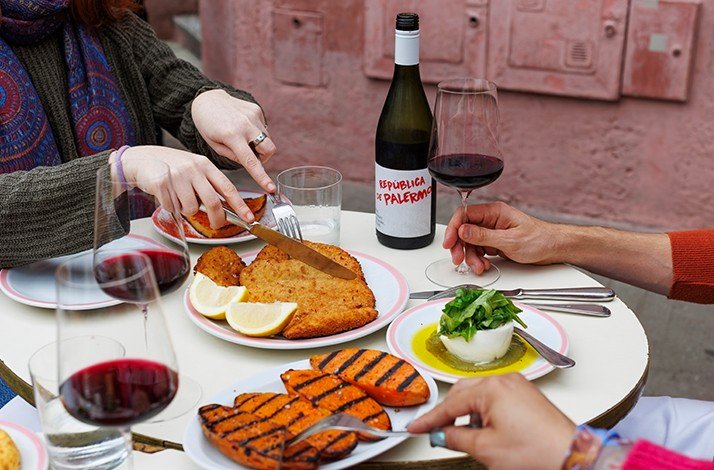 Buenos Aires table with milanesa, grilled sweet potatoes, burrata, and 'República de Palermo' wine.