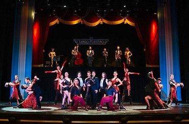 A vibrant tango performance with dancers and musicians on a grand stage