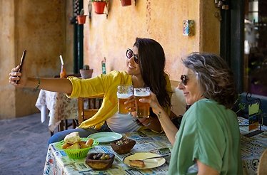 Participants of the food-focused walking tour of Buenos Aires taking a selfie while cheering with glasses of beer