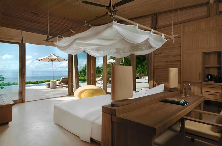 Bedroom in one the villas at the Six Senses Con Dao resort. In the center of the room there is a double bed overlooking the terrace and the sea.