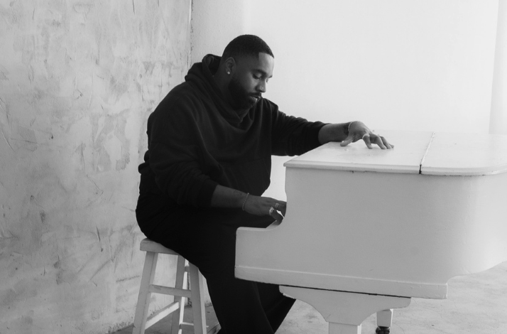 Black and white banner of DIXSON sitting at a white piano, representing premium seating for his live Blue Note LA show.
