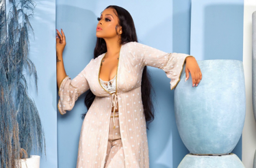American R&B and soul singer Chrisette Michele is shown posing in a light-colored sheer duster.