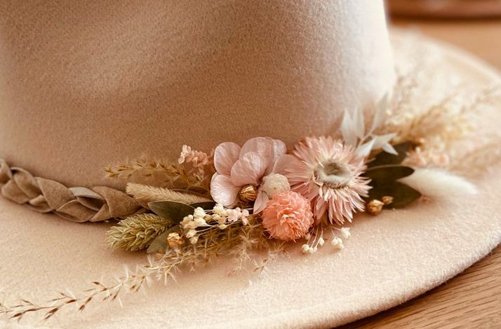 A beige hat adorned with delicate pastel flowers and braided trim