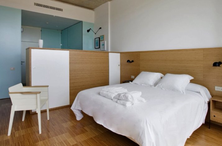 Double bed in a white-and-blue bedroom at the Finca de los Arandinos hotel in Entrena, Spain.