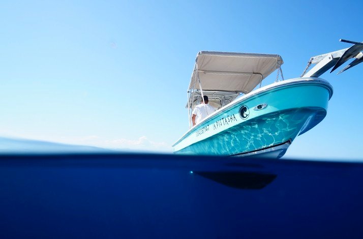 Touristic boat sailing in the sea captured from the water surface from in front.