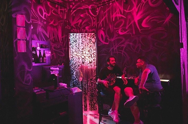 Two men chatting in the TRES MONOS BAR.