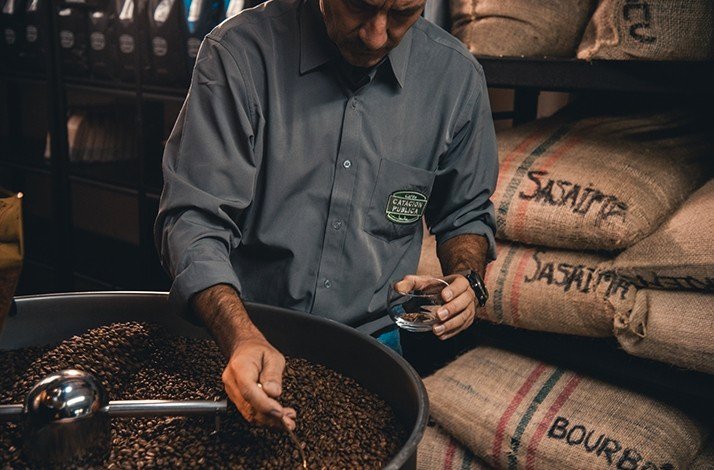 An expert collects coffee beans in a glass at Catación Pública.