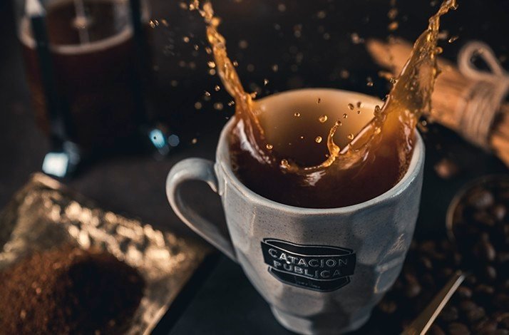 Coffee splashing in a mug at Catación Pública.