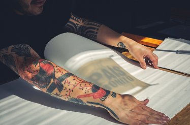 Close-up of illustrator Tavo Garavato creating a print