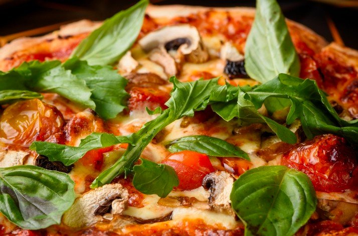 Two cocktails are presented in ornate glasses, one a darker amber color and the other a lighter, golden hue.