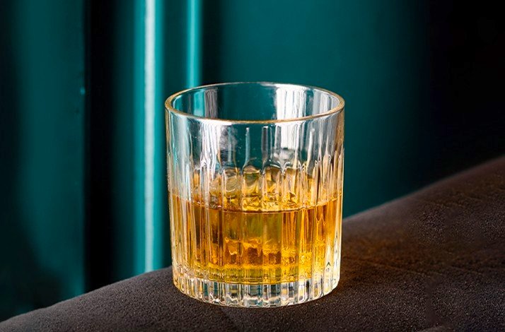 A classic whiskey glass filled with golden spirit on a stylish background