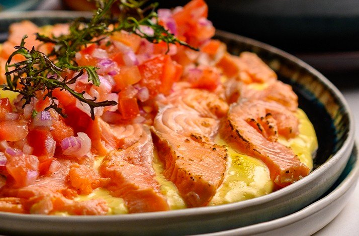 Delicate plate of salmon garnished with diced tomatoes and herbs