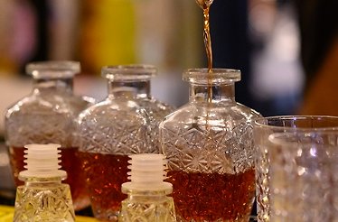 Different bottle of glass being filled with Pisco