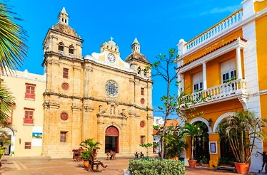 A yellow building featuring a central clock tower, set against a clear sky in Colombia.