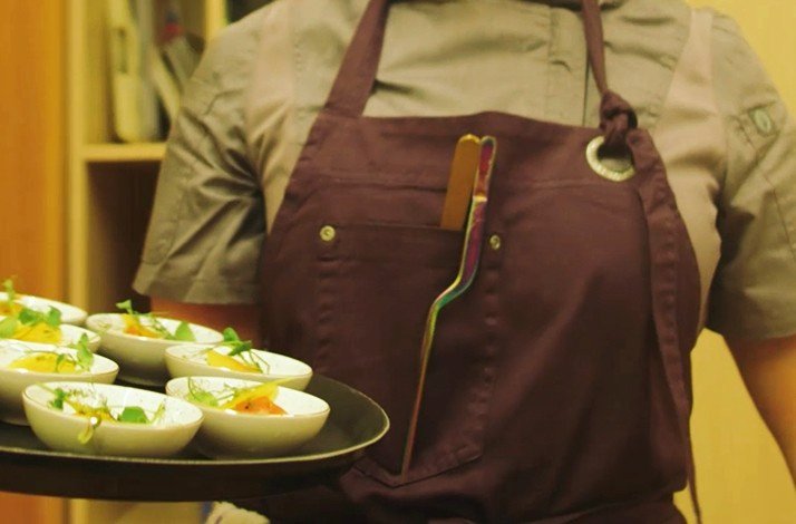 A waiter with a tray of gourmet meals.