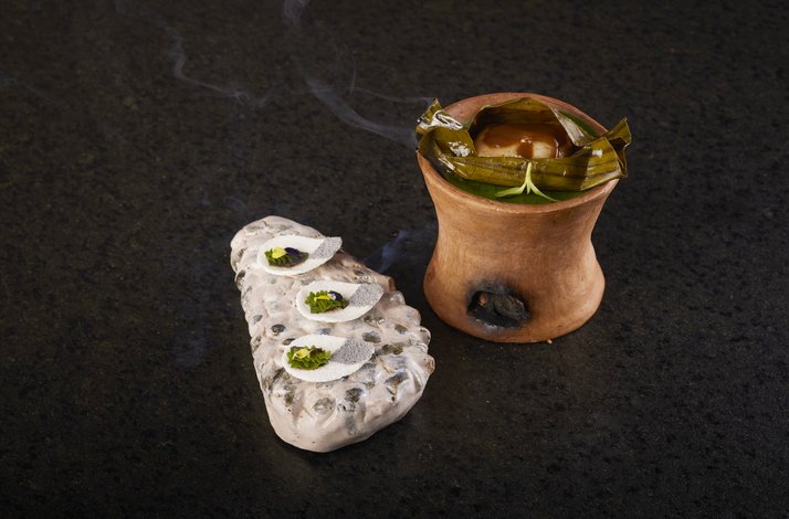 A sophisticated modern culinary presentation of two artful dishes on a dark surface at Restaurante LEO.