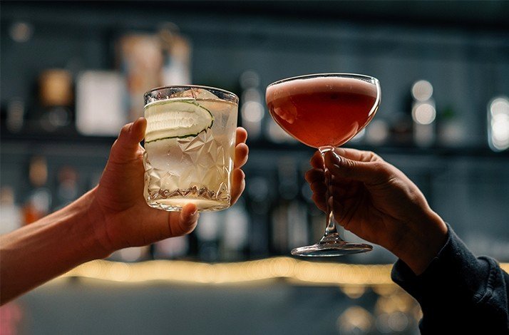 Close-up of hands cheering with cocktails served at Restaurante LEO.
