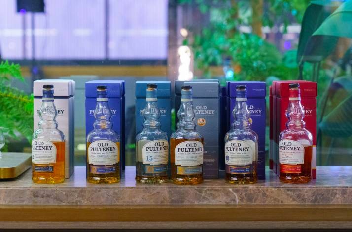A colorful line-up of Old Pulteney whisky bottles with matching boxes in the background.