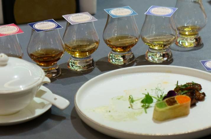   A whisky tasting setup with glasses and a gourmet appetizer plate on a table.
