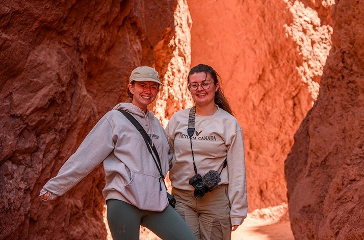 Two girls posing in a rock formation.
