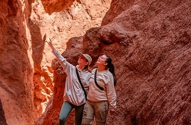 Two girls posing in a rock formation.