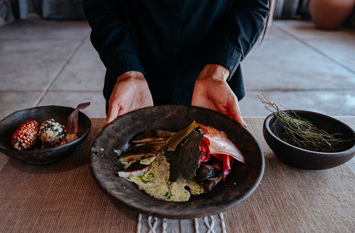 A beautifully plated dish with Andean-inspired ingredients and side bowls