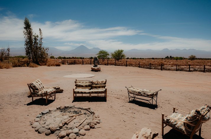 Outdoor seating with rustic chairs, firepit, and stunning desert mountain backdrop