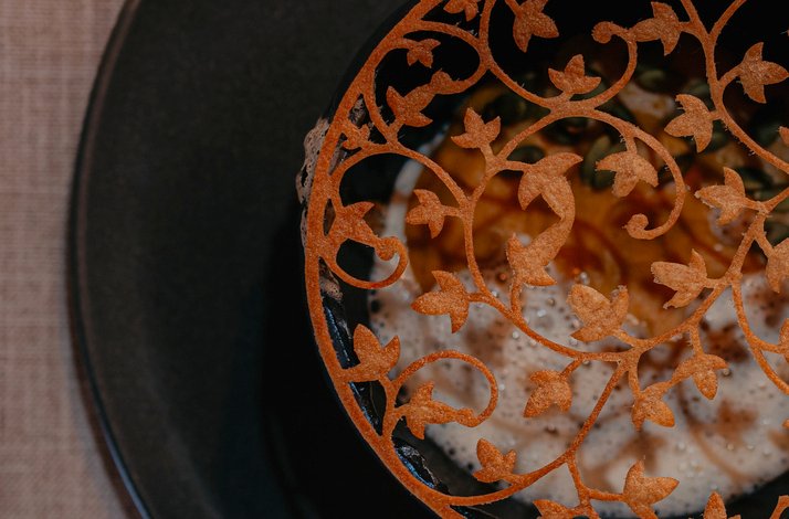 Intricate decorative garnish atop a sophisticated dish presentation