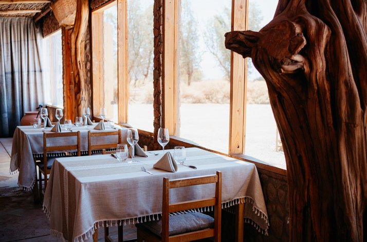 Cozy dining area with wooden tables, natural light, and scenic views