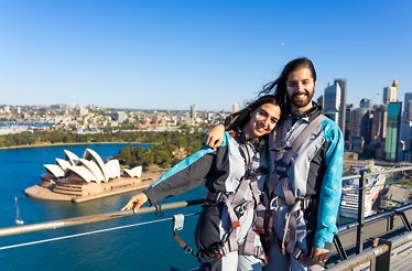 A couple wearing BridgeClimb suits atop the Sydney Harbour Bridge.