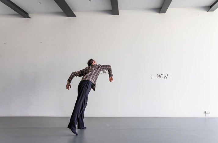 Promotional photo of dancer Melih Kıraç performing at Hara. The word 'now' is written on the wall.