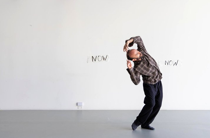 Promotional photo of dancer Melih Kıraç performing at Hara. The word 'now' is written on the wall.