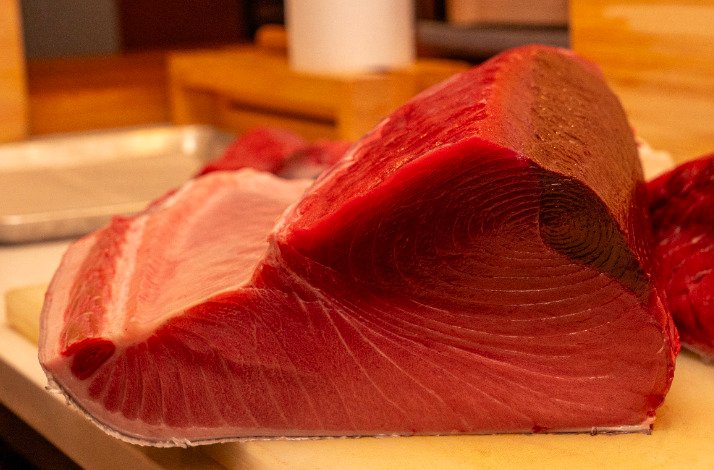 A close-up shot of vibrant red fish meat placed on a table.