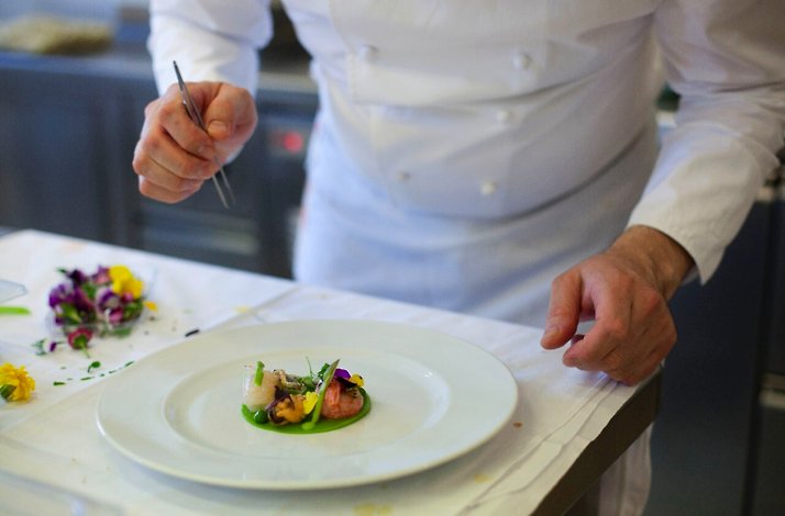 The chef decorates the dish.