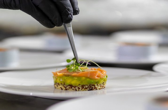 A chef delicately plating a meal.