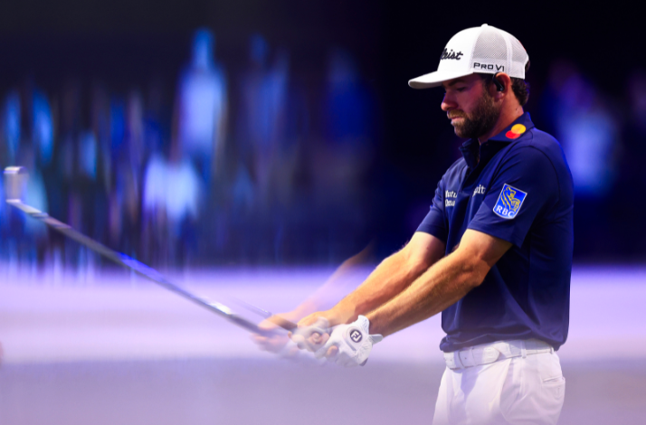 Golfer Cameron Young captured in motion and focused during his swing, set against a blurred background