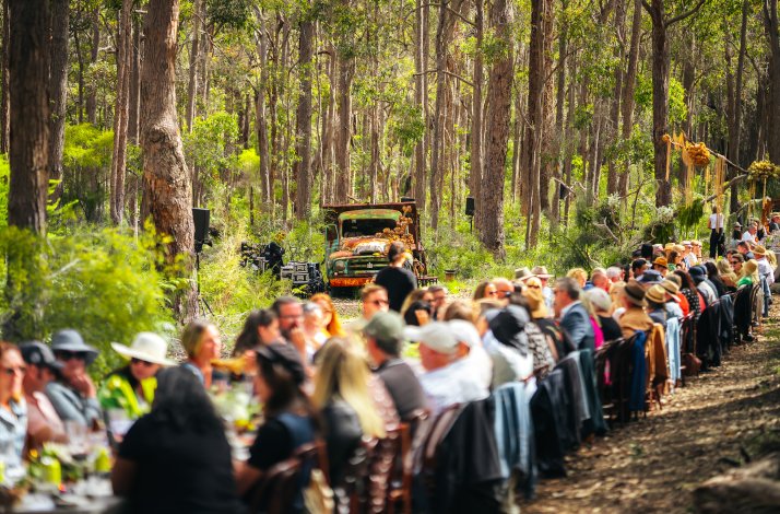 Many people enjoy the Pair'd Festival sitting at a long table.