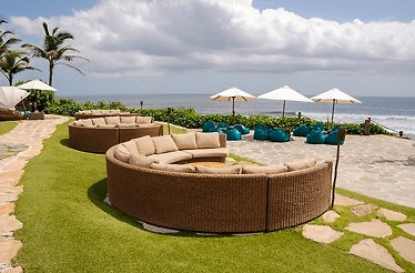 View of Luna Beach Club with daybeds and oceanfront at the coast in Bali.