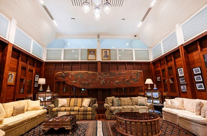 Elegant seating area inside Nai Lert Park Heritage Home with large windows and wooden accents.