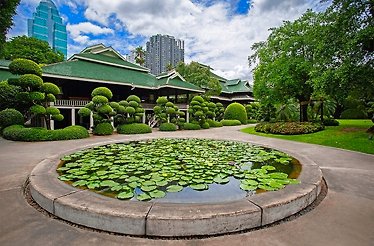 Gardens of Nai Lert Park Heritage Home with city skyline in the background.