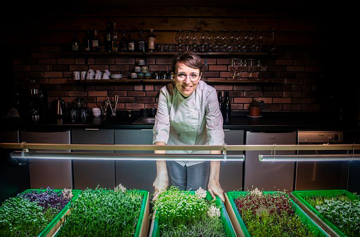 Chef Bára Šimůnková with fresh microgreens inside LEAF restaurant.