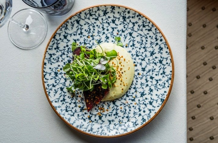 Artistic dish with creamy puree, microgreens, and vibrant beet on a patterned plate at Leaf Restaurant