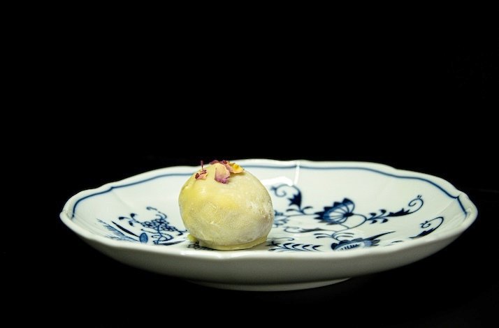 Decorative plate presenting a refined dish under dramatic black-background lighting at Leaf Restaurant