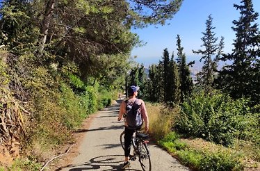 Man on a bicycle admires nature on his way up to Mount Tibidabo, Spain.