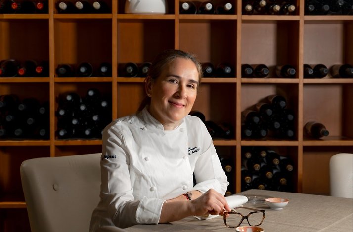 A wine-filled backdrop with a chef's uniform, evoking a culinary focus