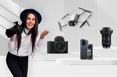 A model posing with a camera next to top photo and video equipment sold at F64 Studio.