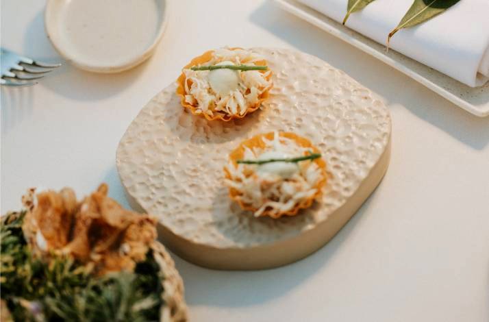 Two small, elegantly presented appetizers on a white serving stone.