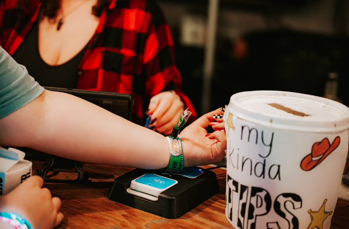 A person getting their VIP wristband scanned.